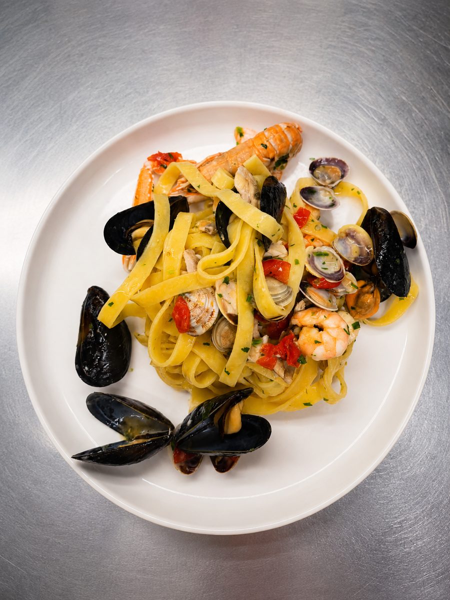 Pasta ai frutti di mare su piatto bianco